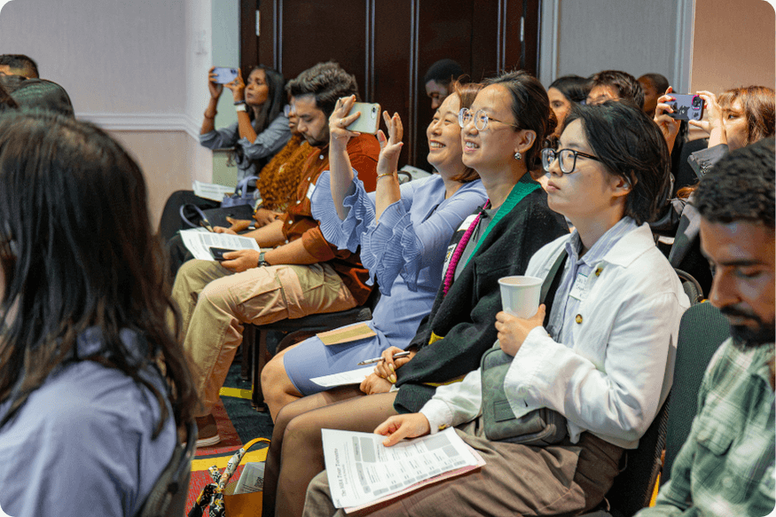 A group of people smiling and scanning information during a presentation
